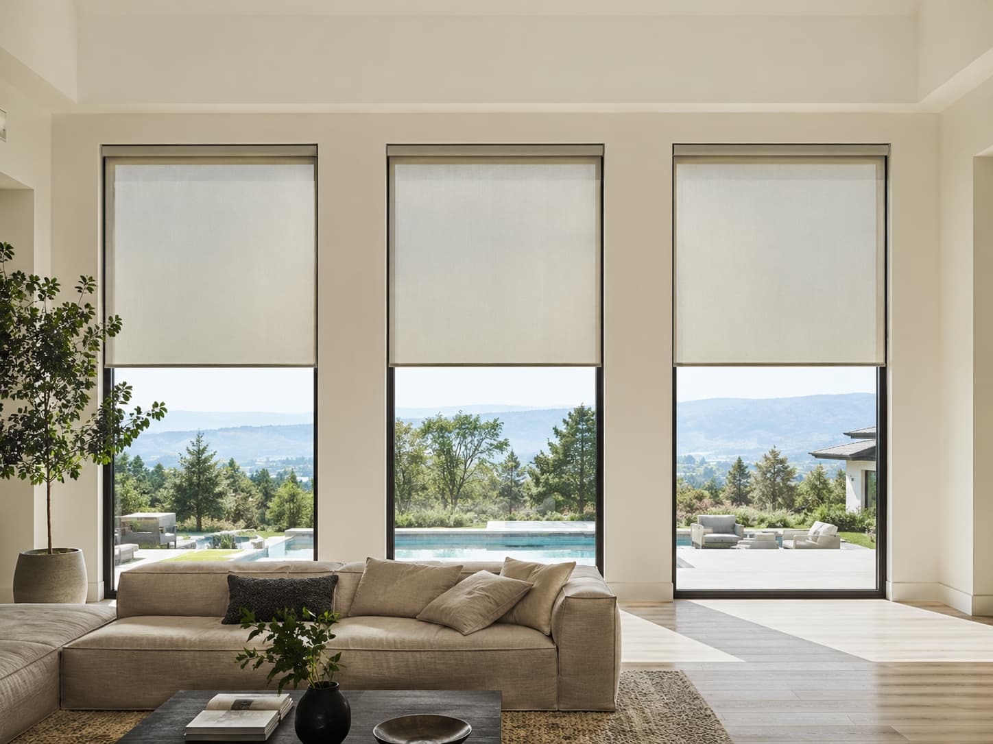 Motorized roller shades at matching heights across three tall windows